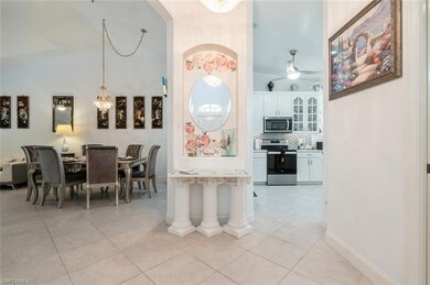 Dining room with light tile patterned floors, arched walkways, and ceiling fan
