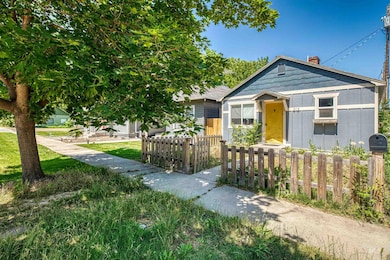 Bungalow with a chimney and a fenced front yard