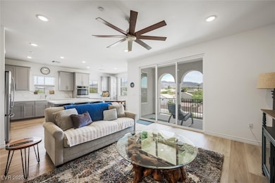 Bright & airey living room with a ceiling fan, lig