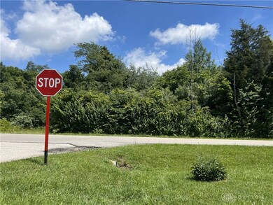 Land is across the road from the stop sign.
See attached arieal map.