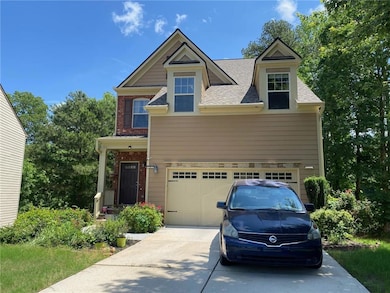 View of front facade with concrete driveway, an attached garage, a shingled roof, and brick siding