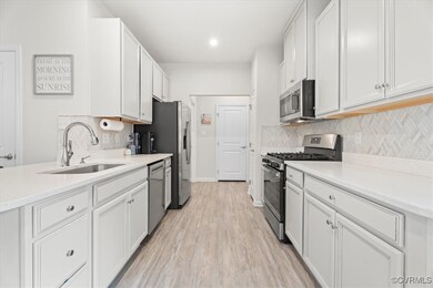 Kitchen featuring stainless steel appliances, a si