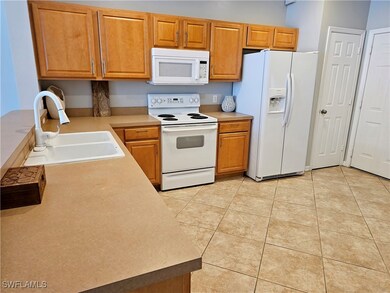 Kitchen featuring white appliances, light countert