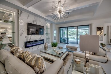 Living room with a tray ceiling, an inviting chand
