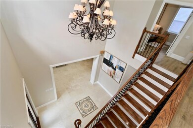 Carpeted cinema room featuring a tray ceiling, ornamental molding, beverage cooler, and bar area