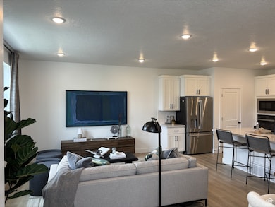 Living room featuring light wood finished floors and a textured ceiling
