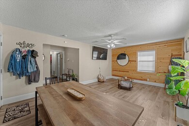 Dining area with a textured ceiling, light wood-ty
