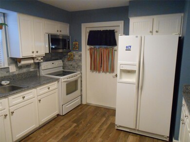 Kitchen with decorative backsplash, white applianc