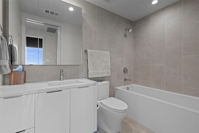 Full bathroom featuring toilet, tile walls, visib