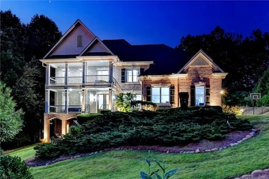 View of front of home featuring a balcony, brick siding, and a lawn