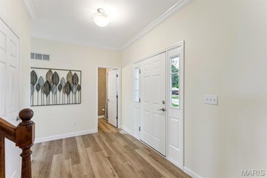 Entryway featuring ornamental molding and light wood-type flooring