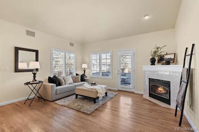 Bright, open living area with firepplace, plantation shutters and beautiful wood flooring.