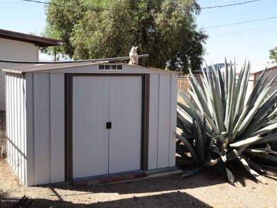 Storage shed in fenced backyard.