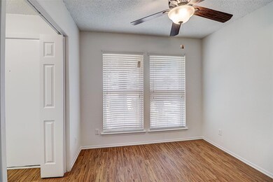 Unfurnished room with ceiling fan, a textured ceil
