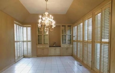 Unfurnished dining area with light tile patterned flooring, a chandelier, and plenty of natural light