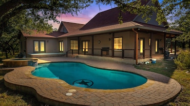 View of pool with a patio and a pool with connected hot tub