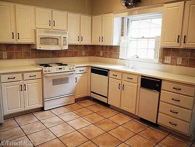 Kitchen. Large, eat-in kitchen with tile flooring, raised panel cabinets, solid surface countertops, porceline sinks, disposal, slide-In range/oven, built-in microwave, dishwasher and compactor.