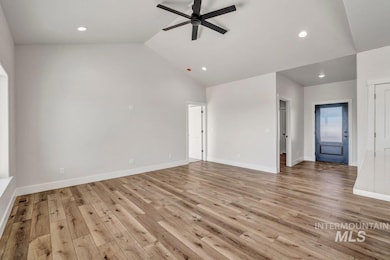 Unfurnished living room featuring ceiling fan, light wood-style floors, lofted ceiling, and recessed lighting