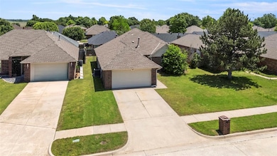 View of front of property with brick siding, a front yard, concrete driveway, and an attached garage