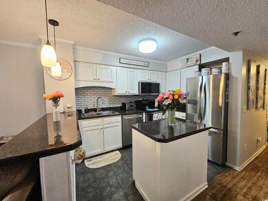 Kitchen featuring white cabinetry, a textured ceil