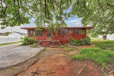 View of front of house with fence and metal roof