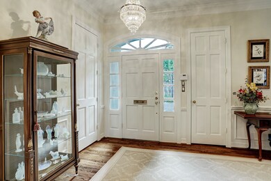 Dramatic entry hall with gleaming hardwood floors,