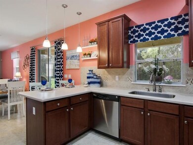 The bright kitchen boasts rich cabinetry, stylish 