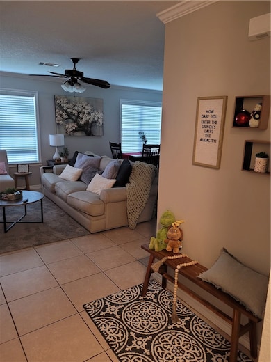 Living area featuring a textured ceiling, light ti