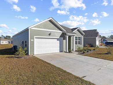 Single story home featuring a front yard and a gar