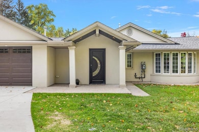 View of front of home with stucco siding, a front yard, an attached garage, and a shingled roof