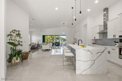 Kitchen with light stone counters, vaulted ceiling