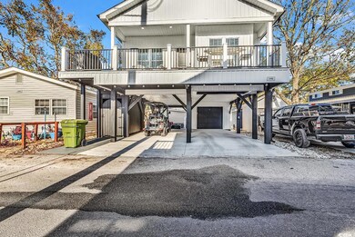View of front facade featuring a carport and a bal