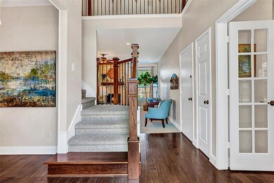 Step inside and notice the gorgeous wood floors and updated iron balusters on the stairs.