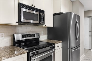 Kitchen with stainless steel appliances, dark ston