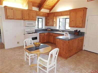 Open kitchen with wood cabinets, title counter top