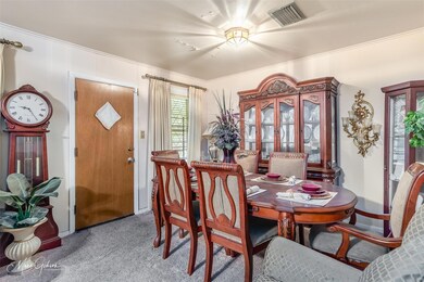 Carpeted dining area featuring crown molding