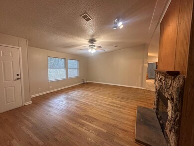 Unfurnished living room with ceiling fan, wood fi