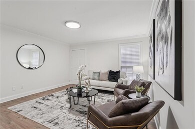 Living area featuring ornamental molding and wood finished floors