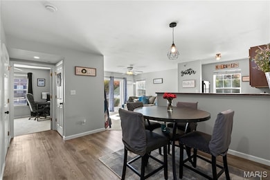 Dining space with a desk, plenty of natural light, wood finished floors, and a ceiling fan