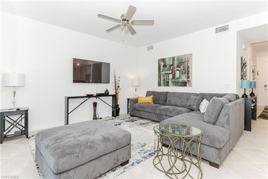 Living area featuring light tile patterned floors and a ceiling fan