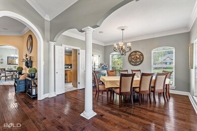 Dining area featuring decorative columns, a chande