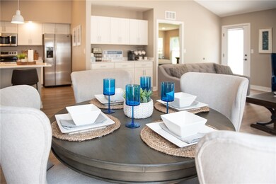 Typical Dining Area in Great Room with Coffee Bar in Background & Doorway to Primary Bedroom
