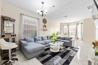 Living room featuring a textured ceiling and a chandelier