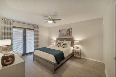 Bedroom featuring access to outside, a textured ceiling, ceiling fan, and wood-type flooring