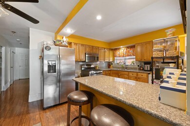 Kitchen with appliances with stainless steel finishes, a sink, a peninsula, and wood finished floors