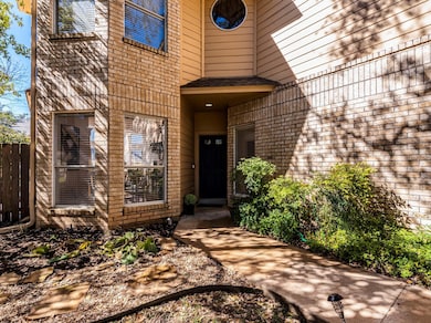 Doorway to property featuring fence and brick sid
