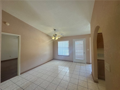 textured ceiling, light tile patterned floors, and