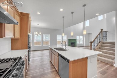 Kitchen with dishwasher, wall chimney range hood, open floor plan, range with gas stovetop, and a fireplace