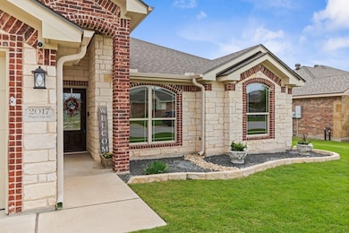 View of exterior entry featuring a shingled roof,