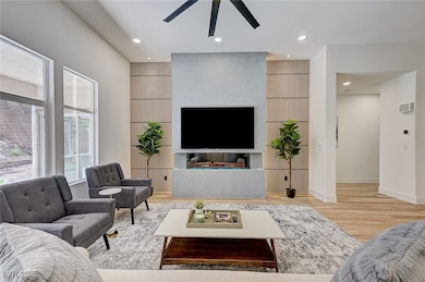 Living area with ceiling fan, wood finished floors